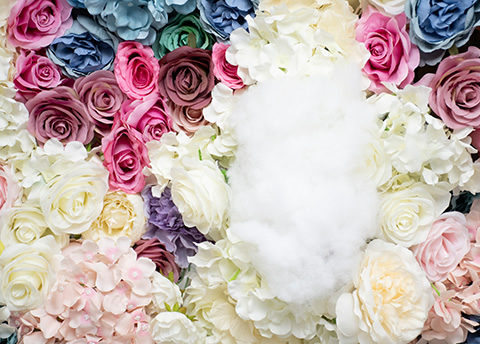 色とりどりの花の中に白い綿が置かれた写真。