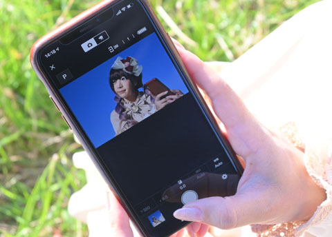 スマホ上でアプリを使って「自分撮り」している女性の手元の写真。
