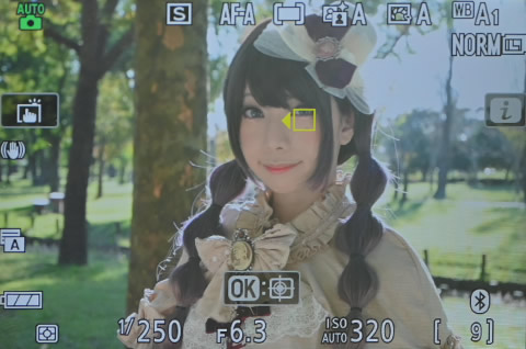 瞳AFでピント合わせしているカメラの液晶画面に映る女性の写真（瞳AF説明写真）。