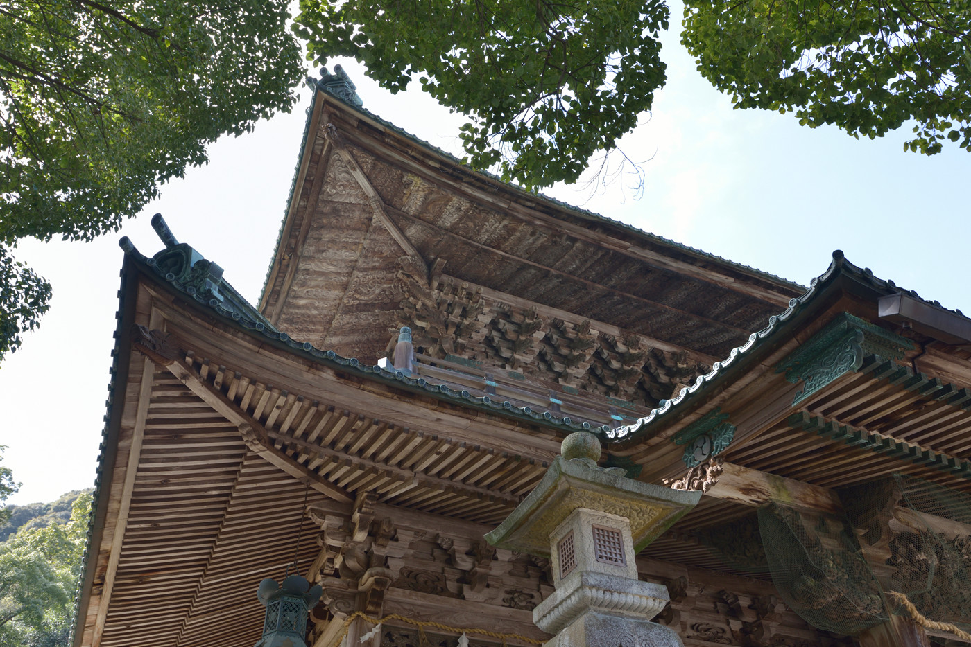 ワイド端の16mmでパースを活かし、手前にある「事比羅神社」と記された古い額の美しい木目を捉えつつ、建物の奥行を感じさせるダイナミックな構図を狙った。